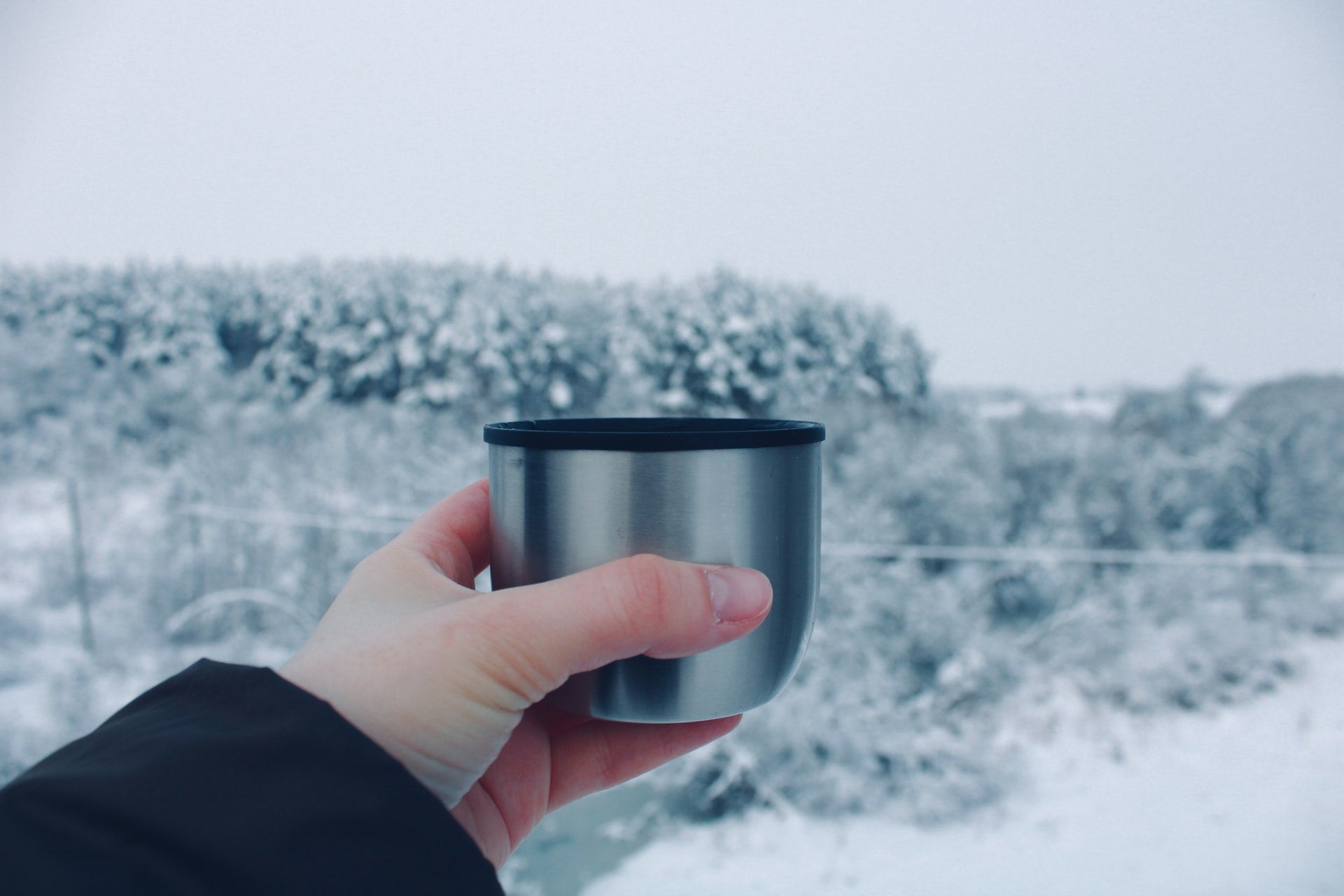 Hand mit Thermobecher